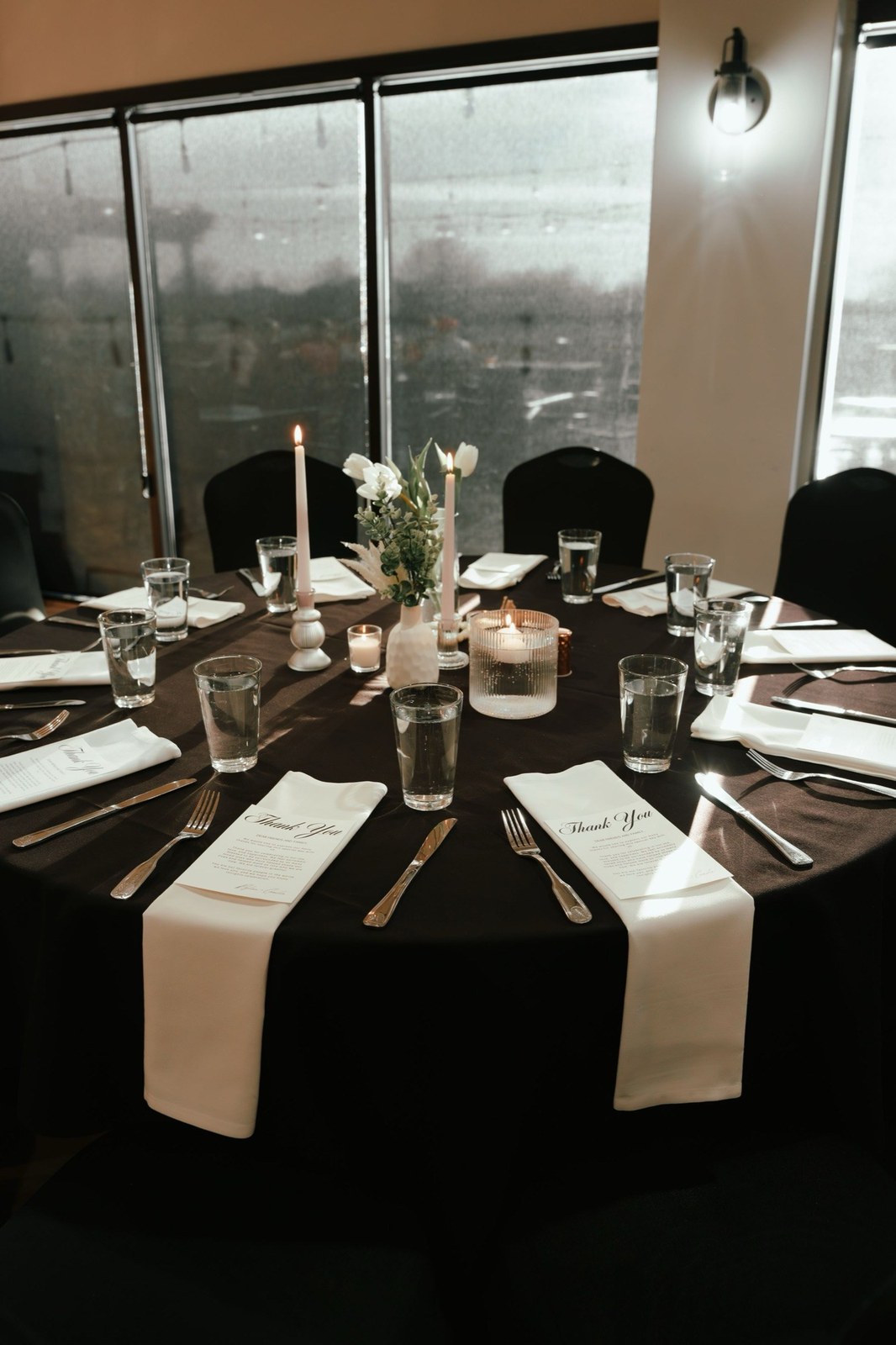 Reception tables set beneath city-view windows
