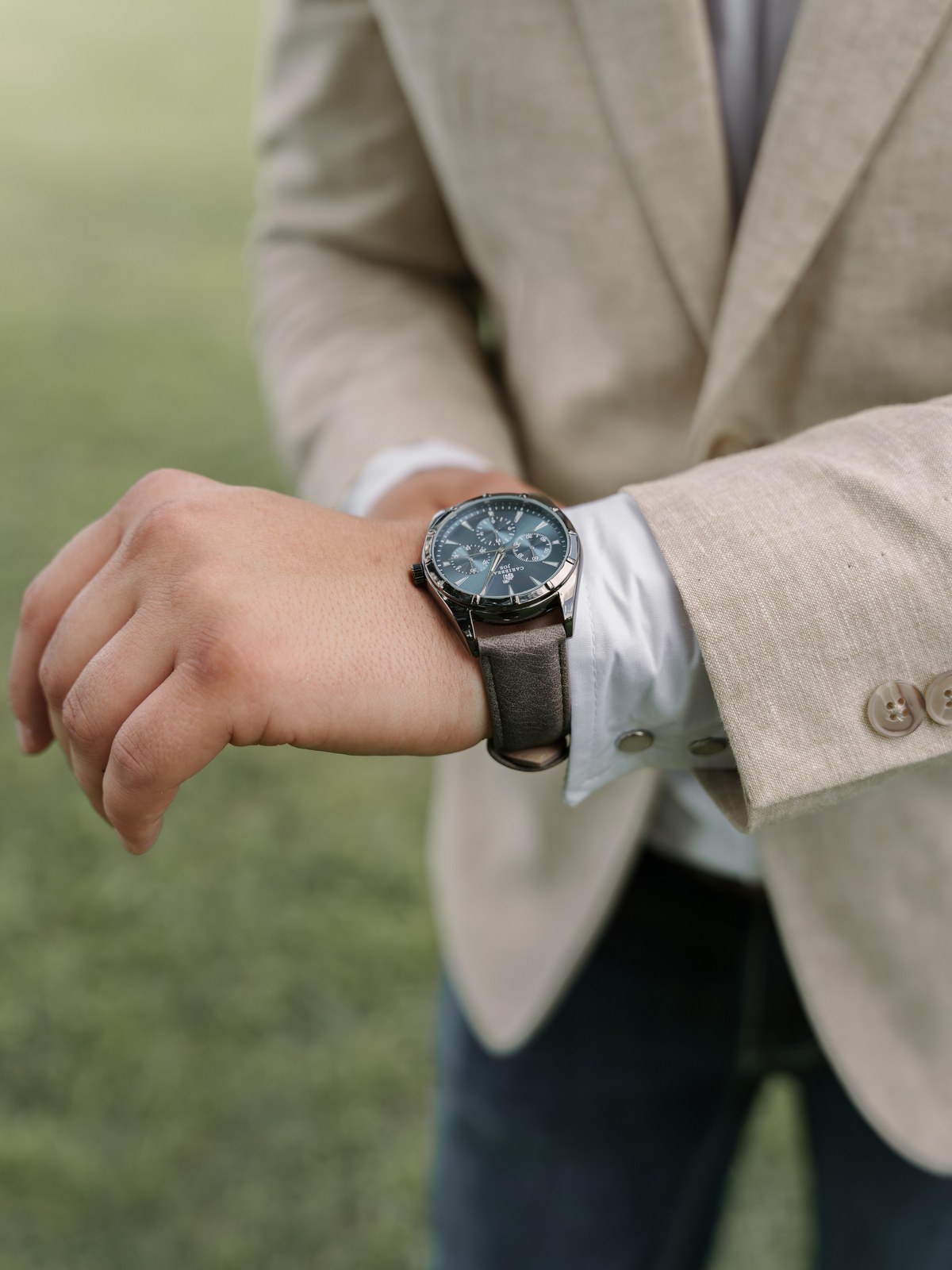 Groom adjusting his watch and jacket sleeve