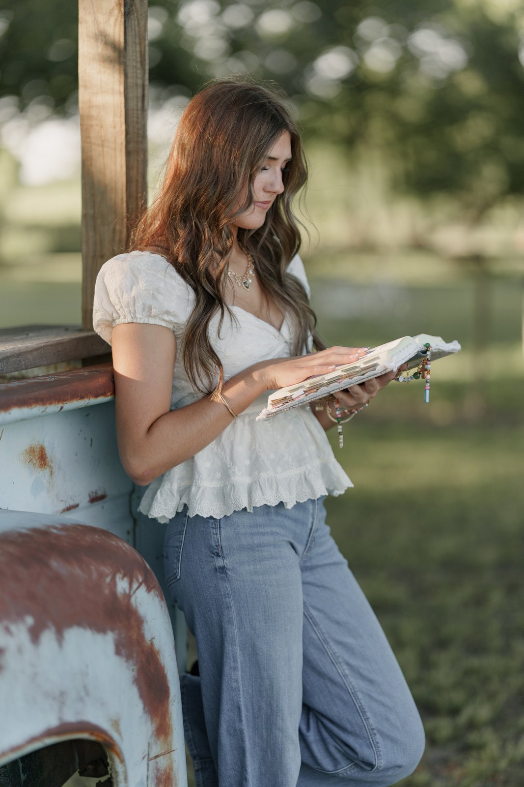 Woman reading beside a vintage truck