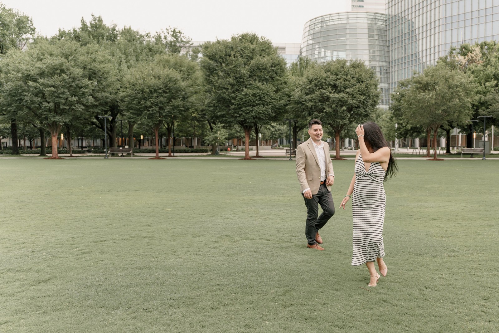 Couple walking hand in hand across a city park