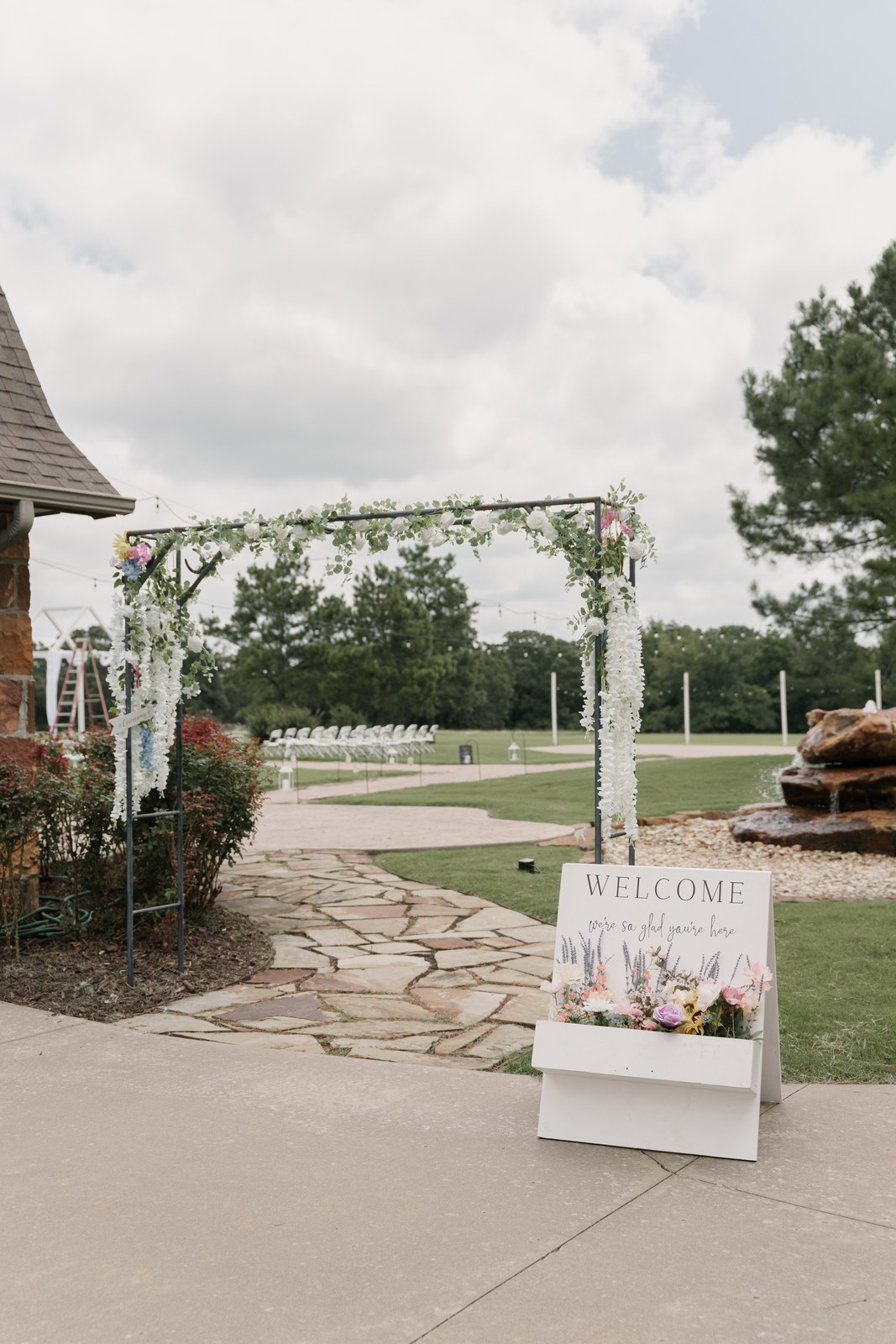 Ceremony arch and welcome sign at an outdoor venue