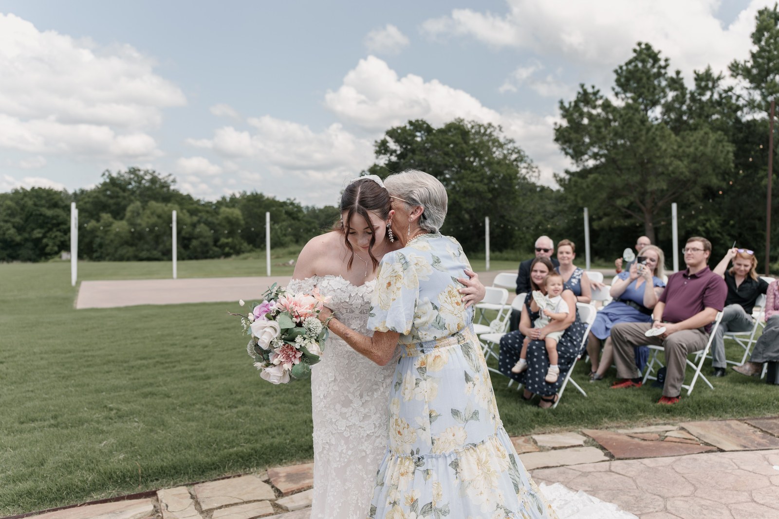 A bride embracing her grandmother at an outdoor Oklahoma ceremony