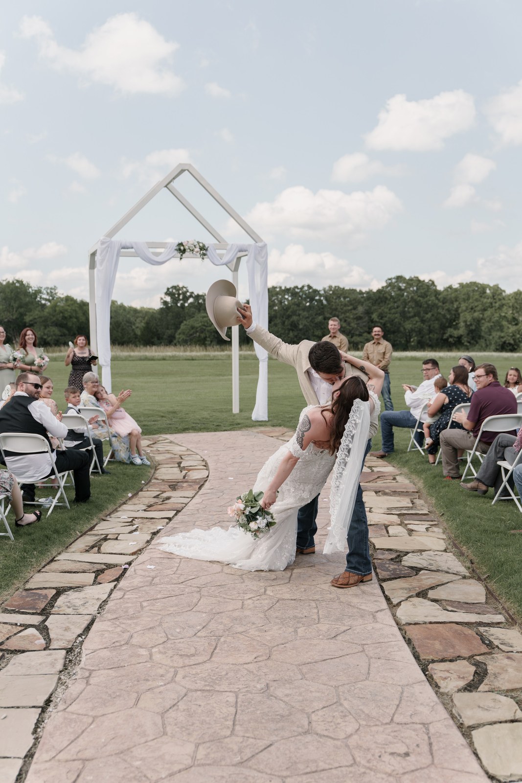 Groom dipping the bride on the stone aisle