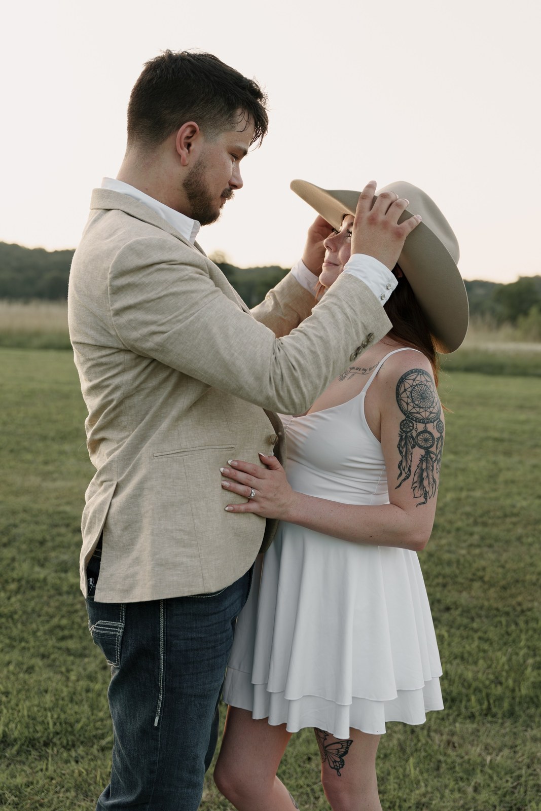 Groom placing his hat on the bride