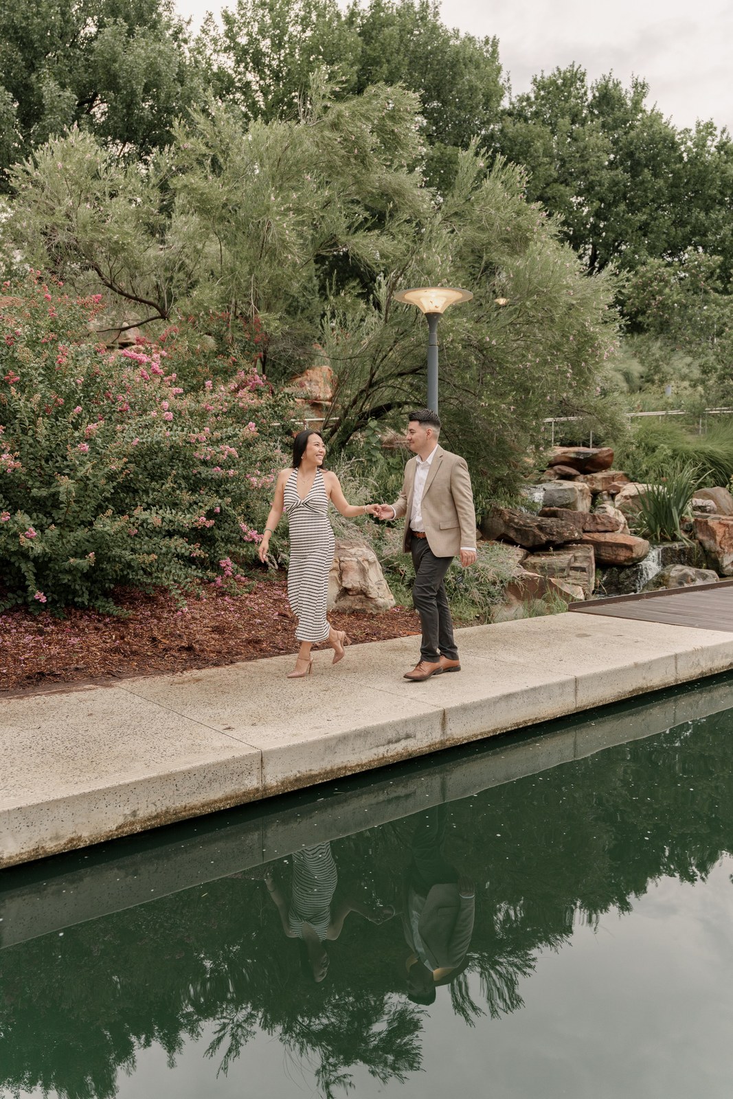 Couple strolling along a garden path by the water