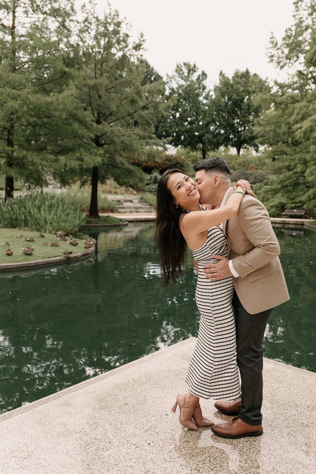 Couple embracing beside a reflecting pool