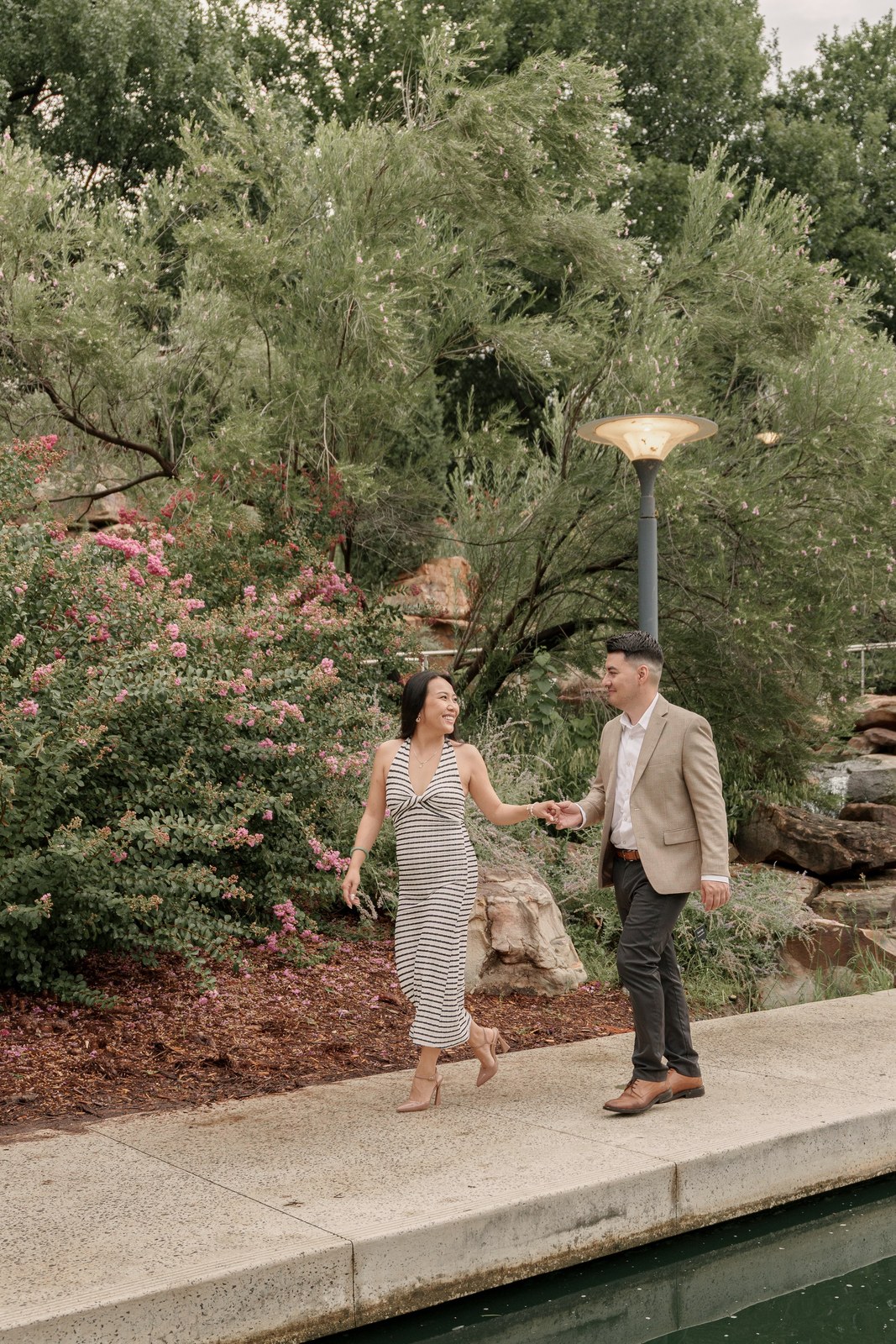 Couple walking through a garden by a lamp post