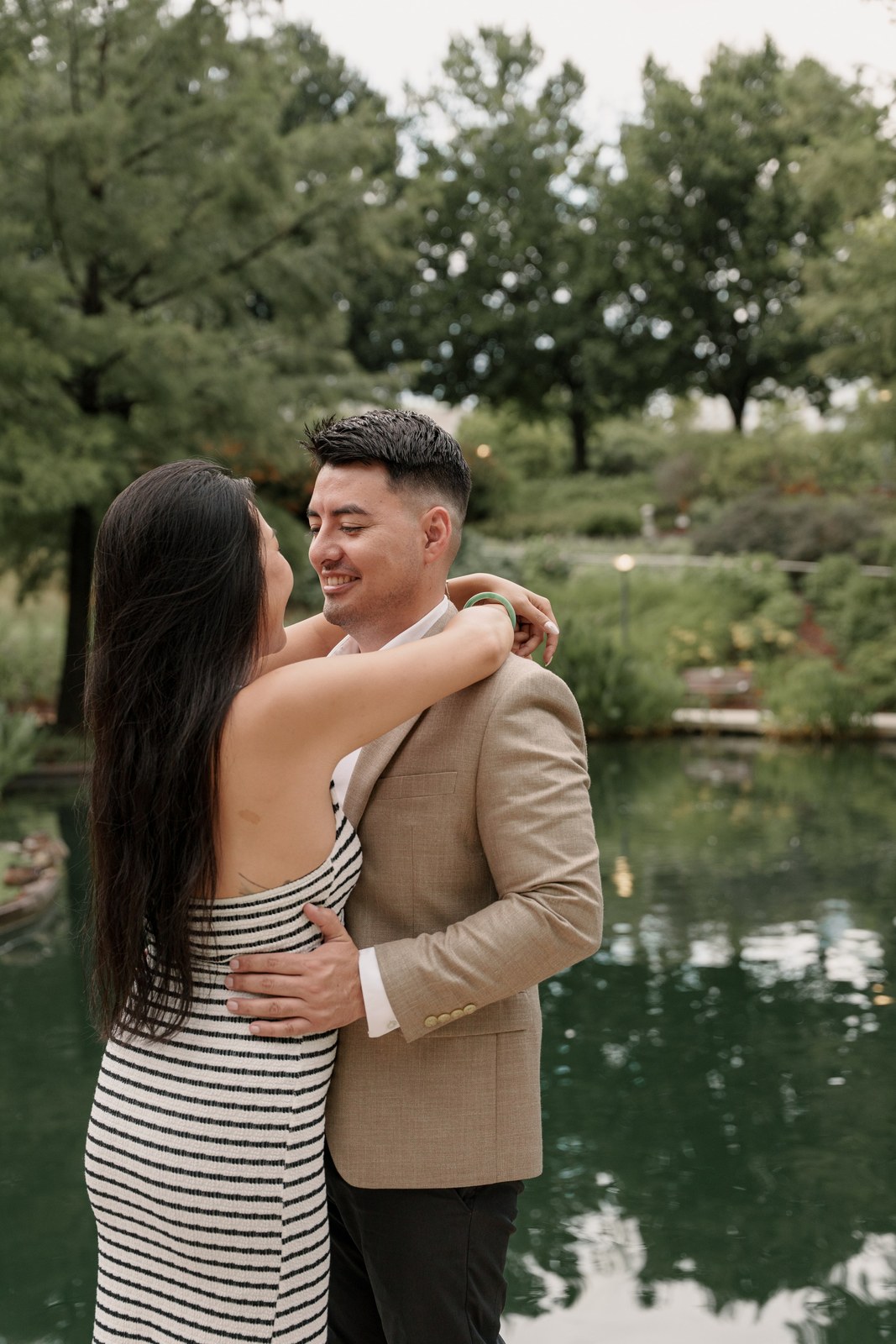 Couple laughing together beside a reflecting pool