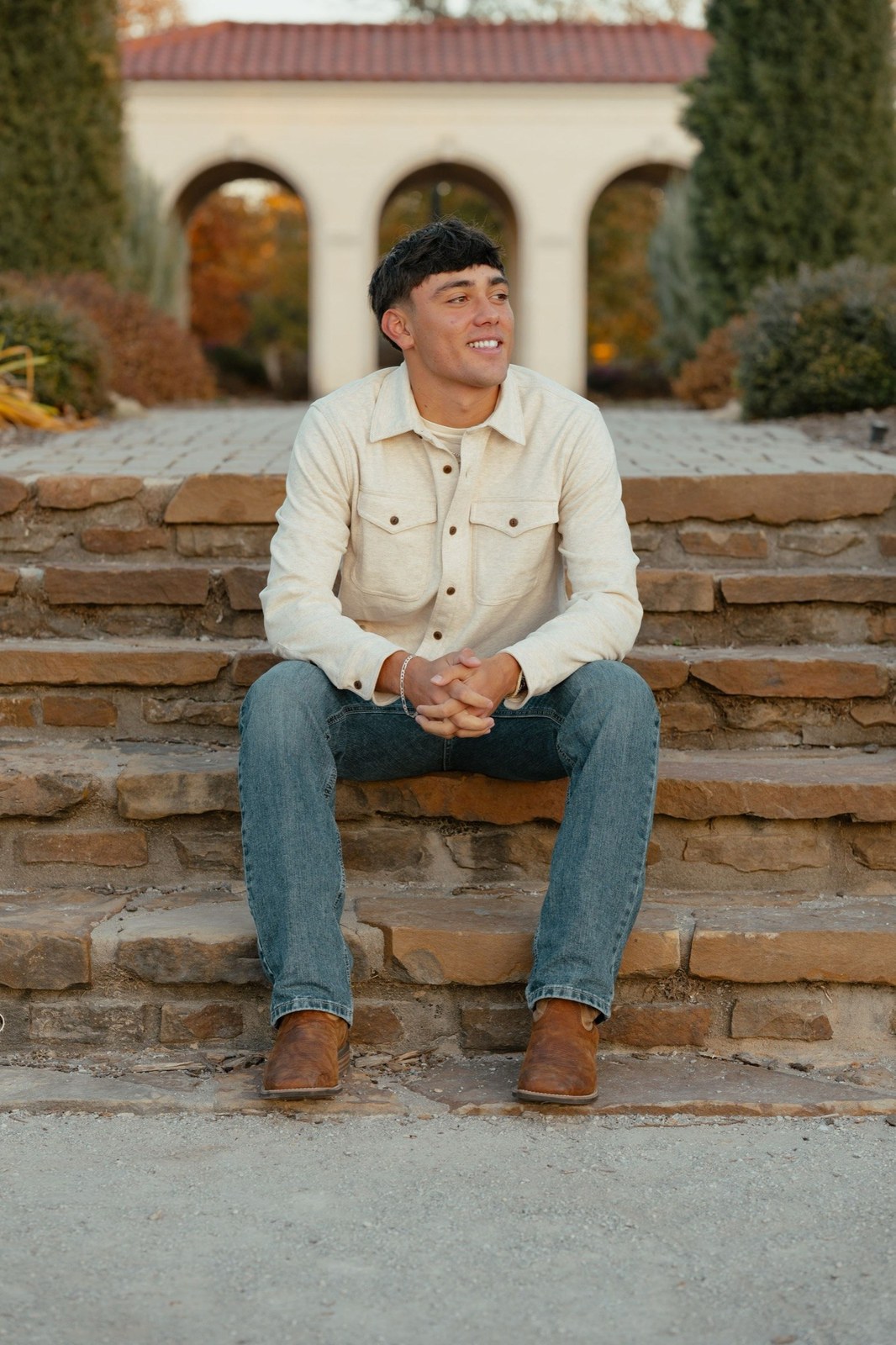 Man seated on stone steps in a garden