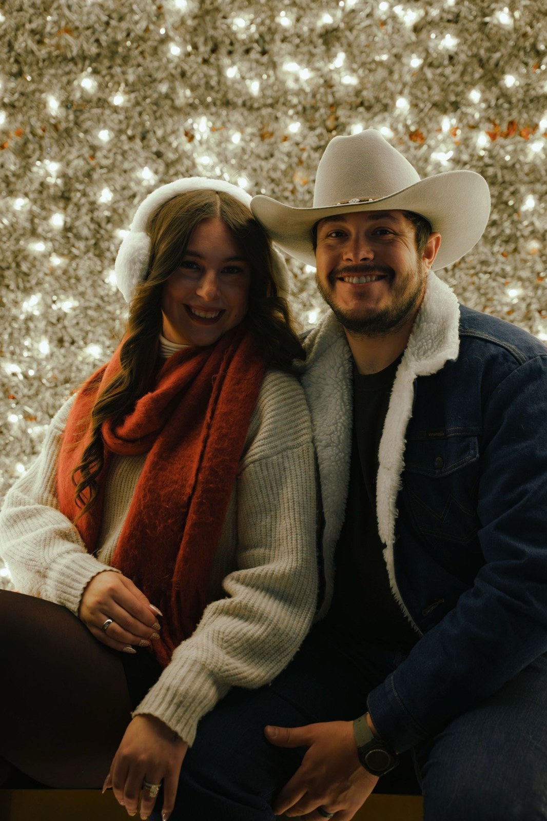 Couple sitting close together against a glittering backdrop