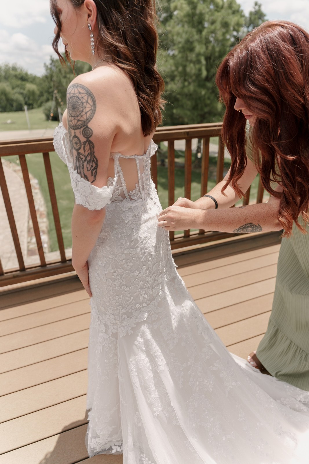 Bride in her lace gown at a lakeside deck